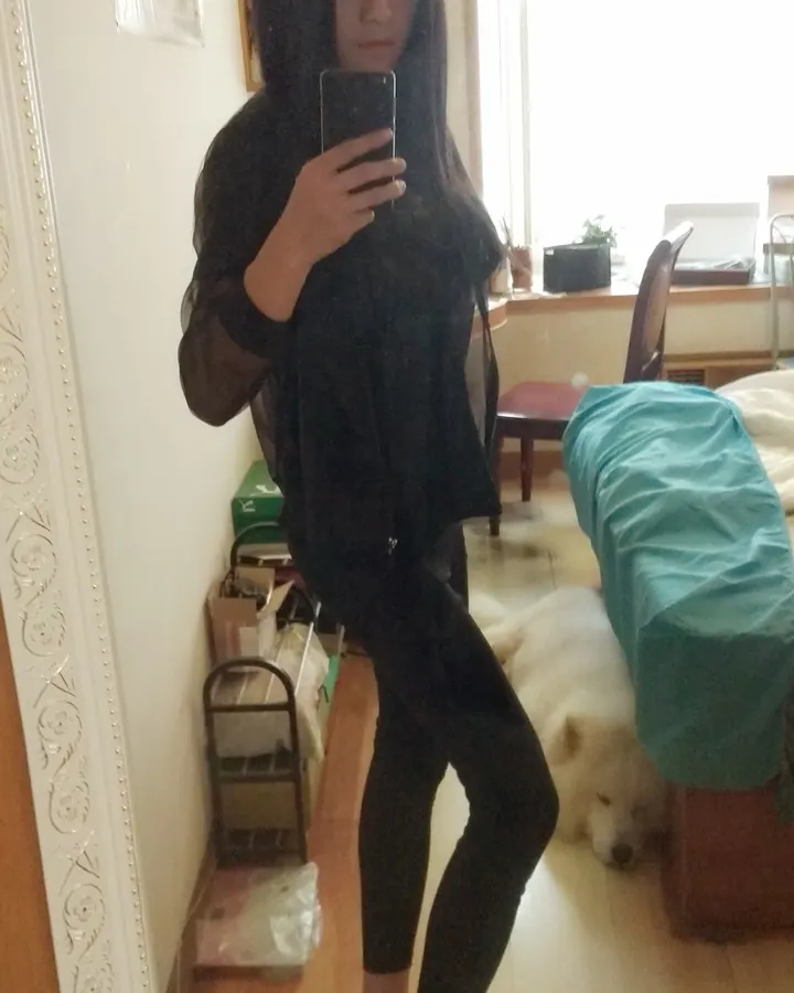 femme brune en chemise noire et legging, selfie dans un miroir