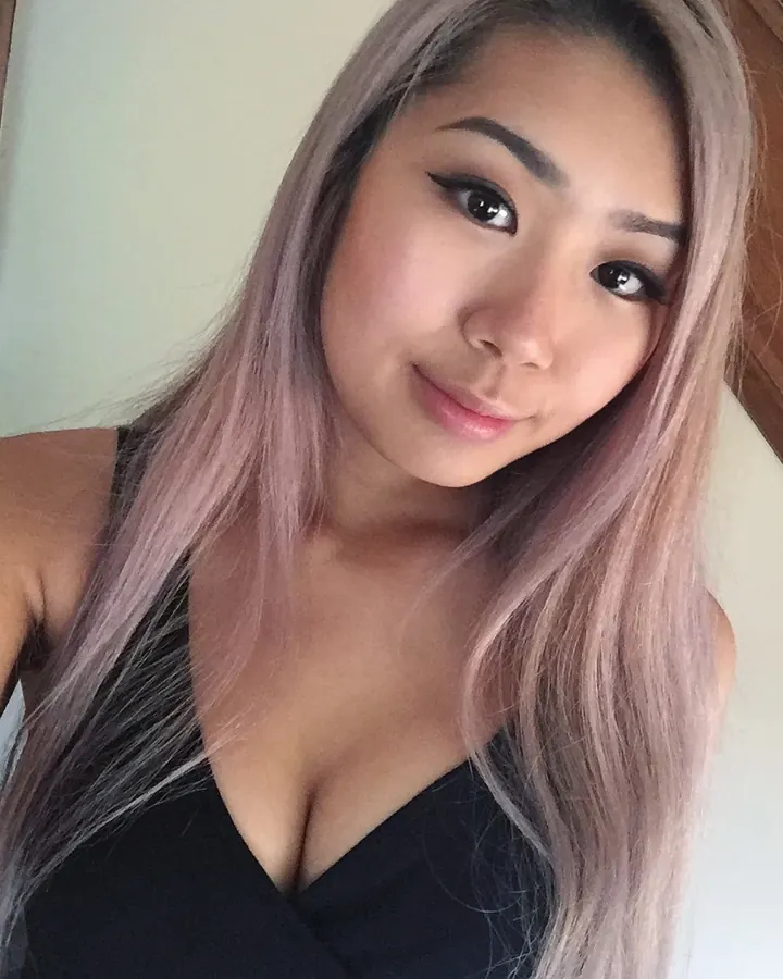 Jeune femme aux cheveux gris en lingerie blanche, posant en intérieur.